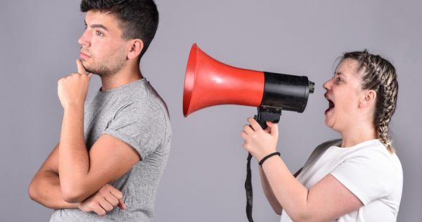 young girl shouting into megaphone at guy who can't hear